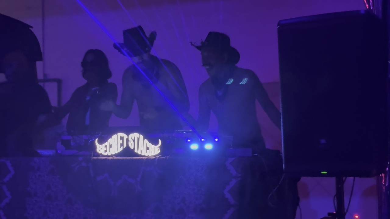 a closer view of the DJs behind the lit booth