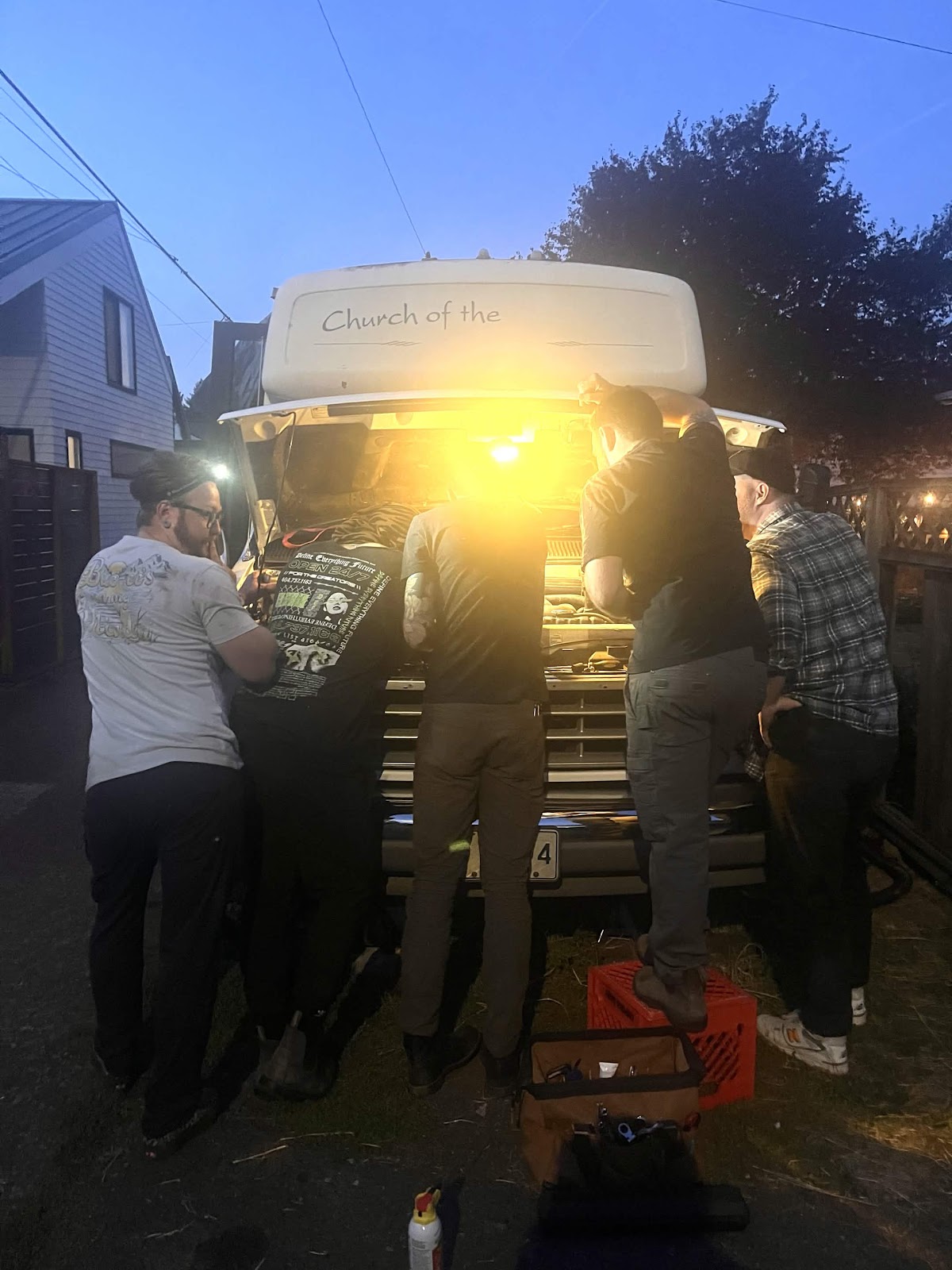 the crew at Buck’s open hood under a bright work light